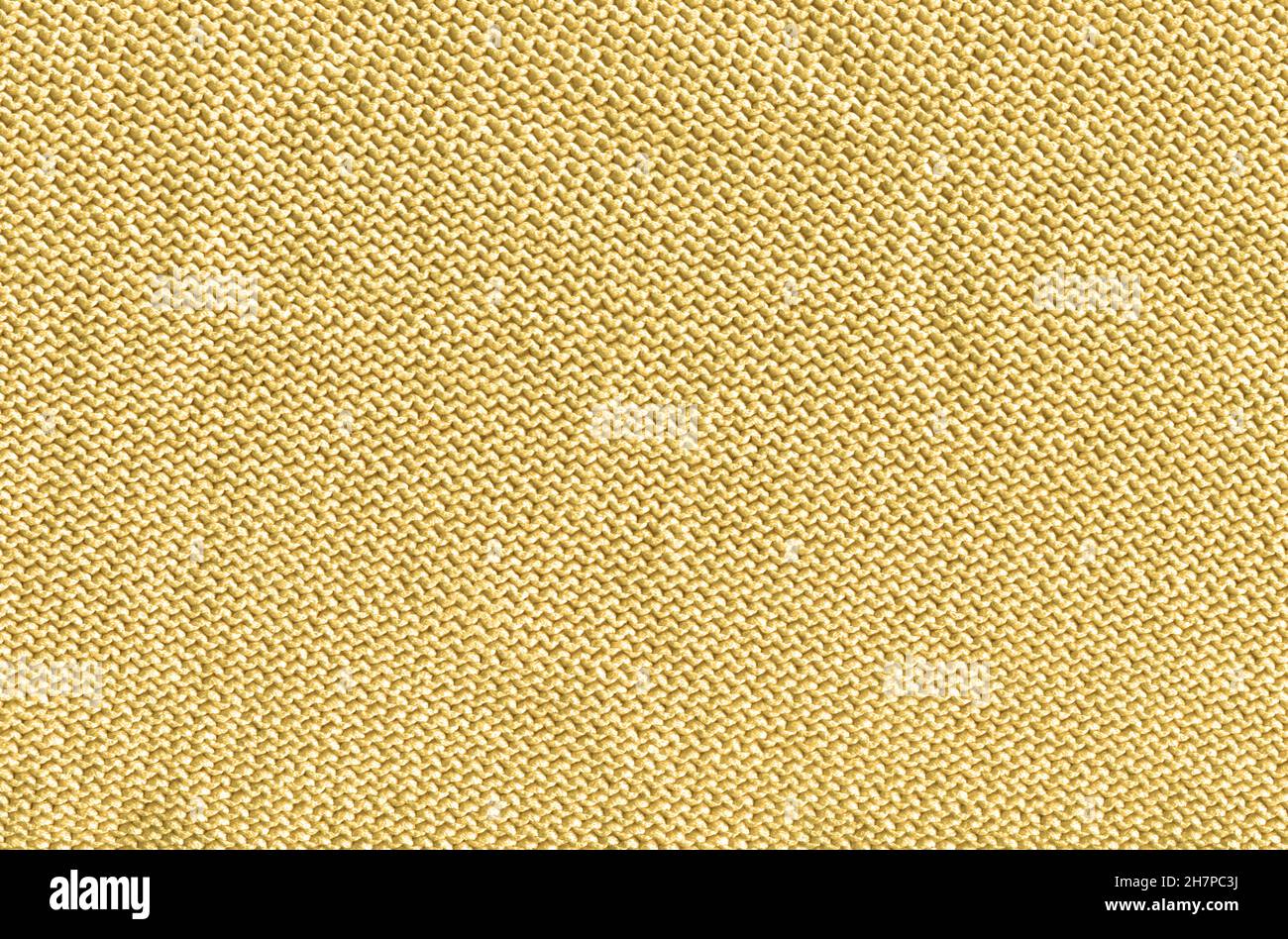Tessuto caldo in maglia leggera di colore sabbioso. Senape fatto a mano accogliente panno caldo. Fondo lavorato a maglia color senape. Foto Stock