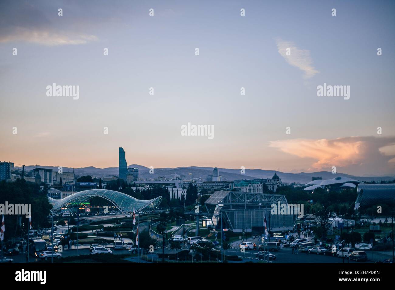 Vista della città con edifici moderni e parco in Georgia. Parco d'arte moderna al tramonto. Nuova architettura in Europa. Tramonto spettacolare a Tbilisi. Foto Stock