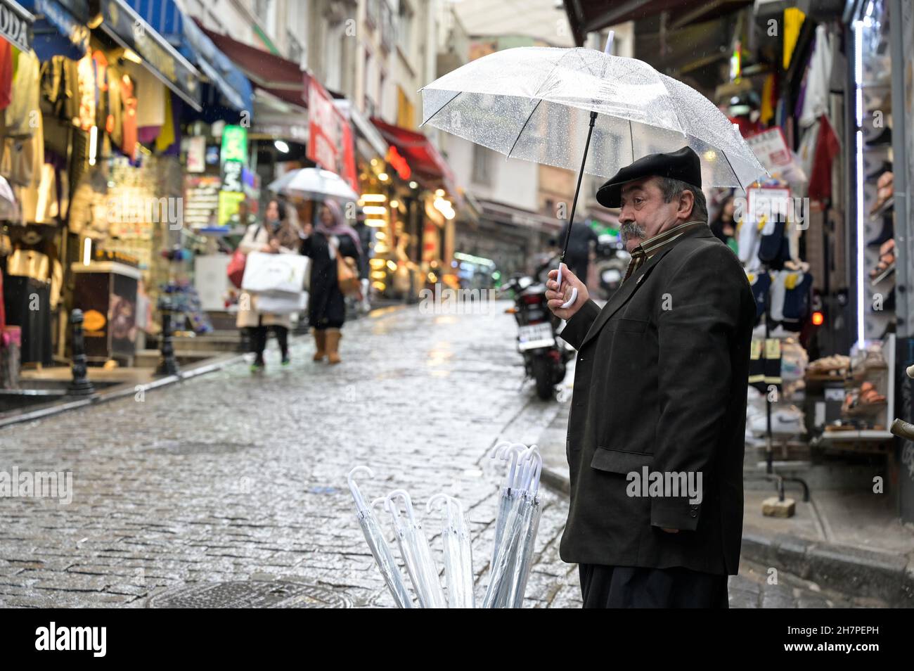 TURCHIA, Istanbul, Beyoglu, venditore di strada che vende ombrelloni durante la pioggia / Türkei, Istanbul, Stadtteil Beyoglu, Straßenverkäufer verkauft Regenschirme im Regen Foto Stock