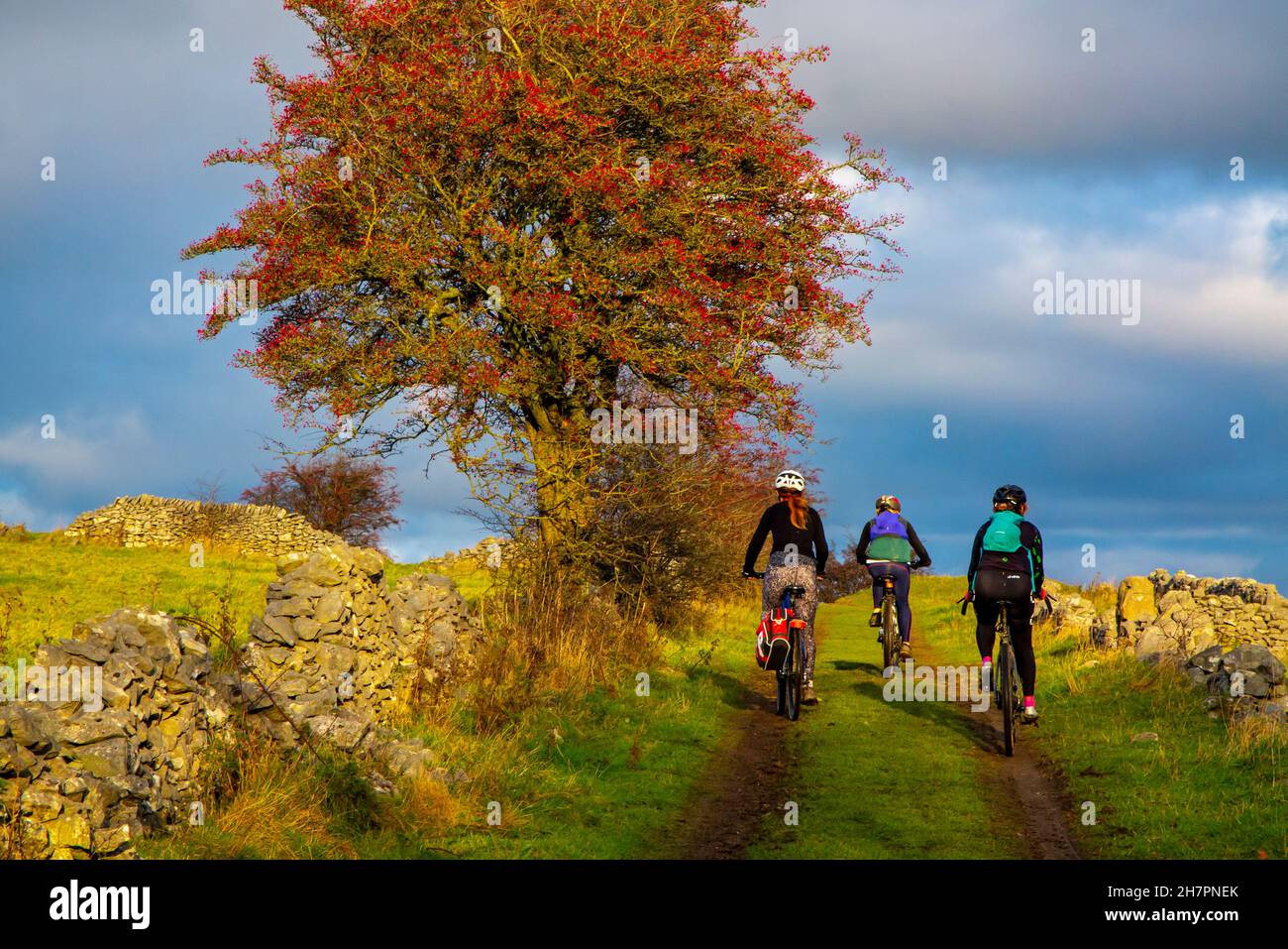 Tre donne in mountain bike a Middleton Moor vicino a Wirksworth vicino all'High Peak Trail nel Derbyshire Dales Peak District Inghilterra UK Foto Stock