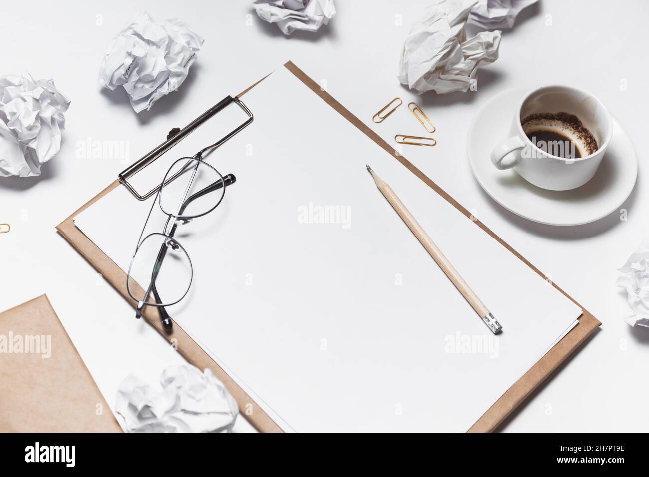 Carta sminuzzata sparsa, tazze vuote di caffè sul tavolo di un lavoratore creativo. Crisi creativa. Concetto di stress, problemi di salute mentale e mancanza di me Foto Stock