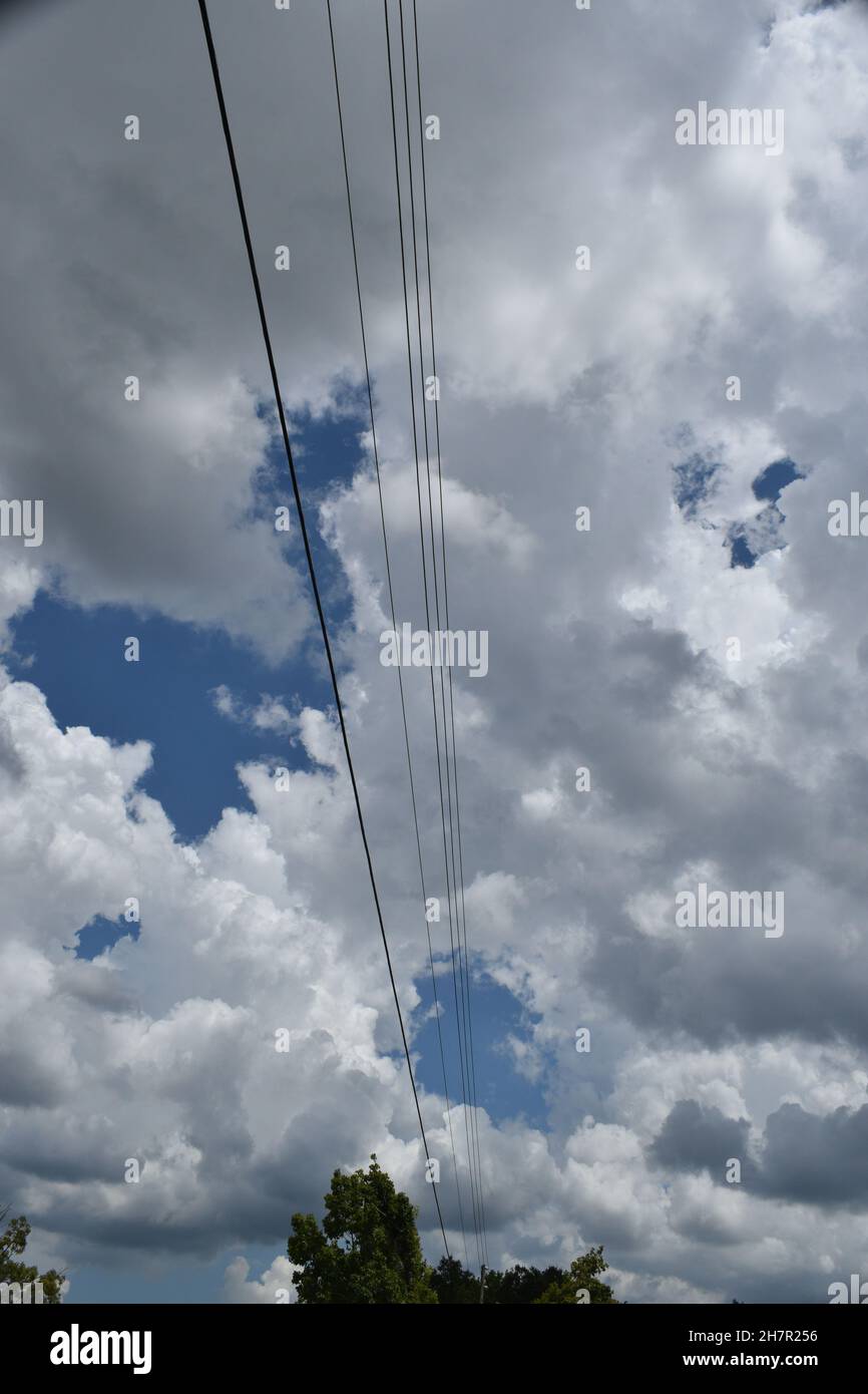 I fili paralleli si estendono su un cielo nuvoloso. Foto Stock