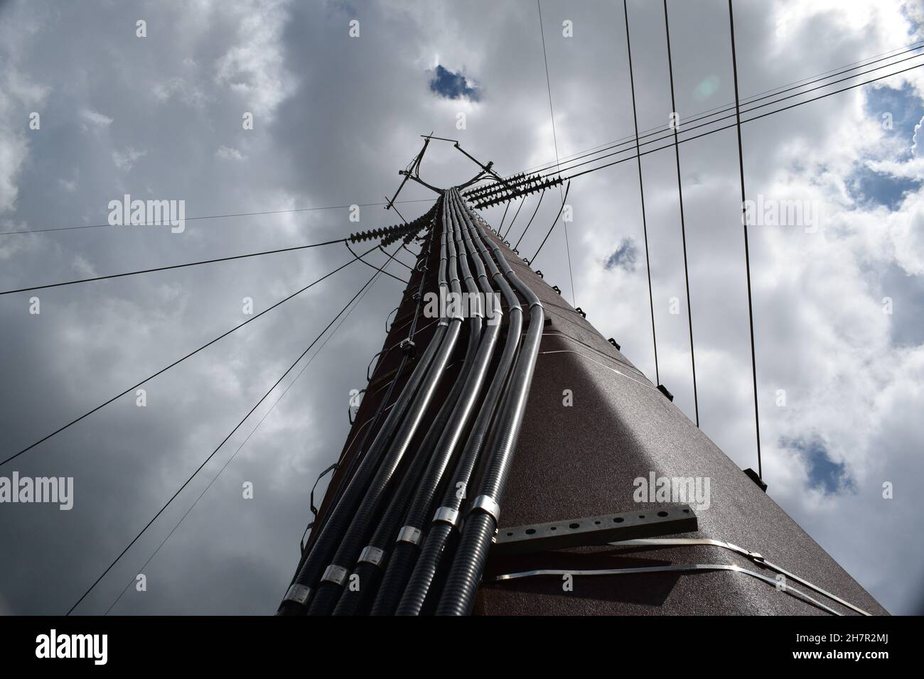 Un grande cavo dati corre su una torre di telefono cellulare alta. Foto Stock