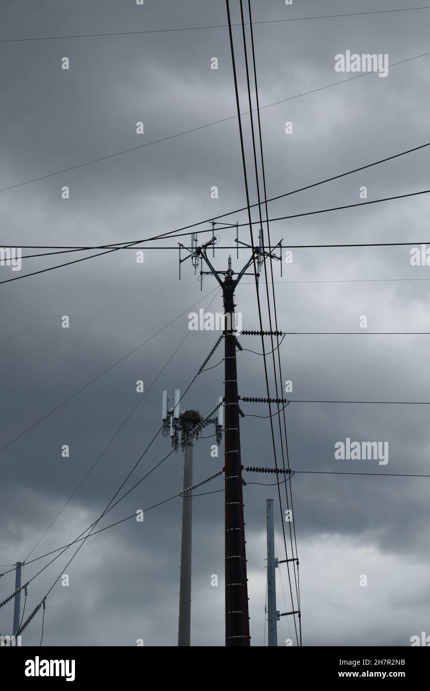 I fili attraversano il cielo nuvoloso da più direzioni. Foto Stock