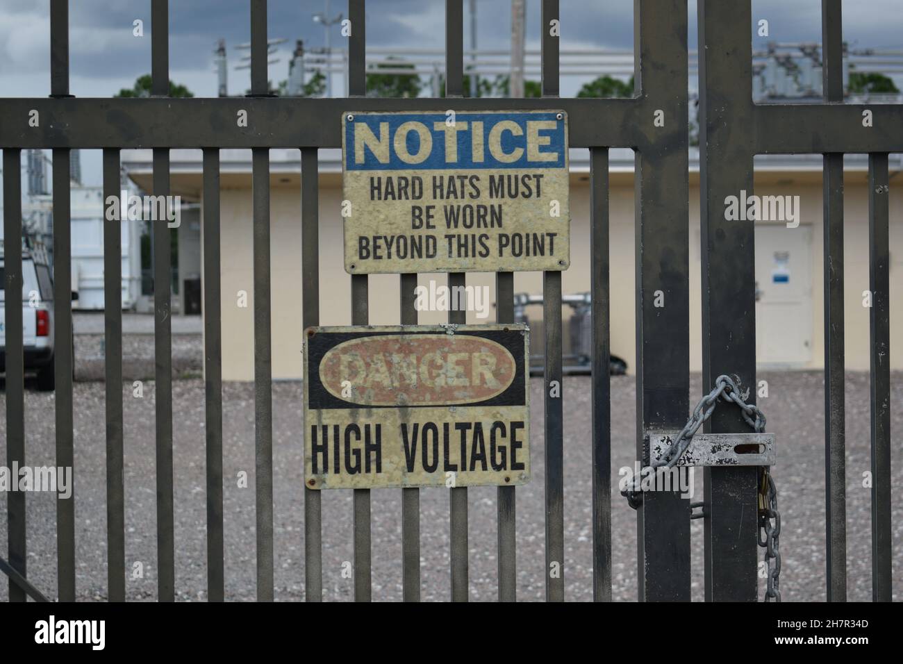 I segnali di avvertimento sono apparsi sul cancello di una sottostazione elettrica. Foto Stock