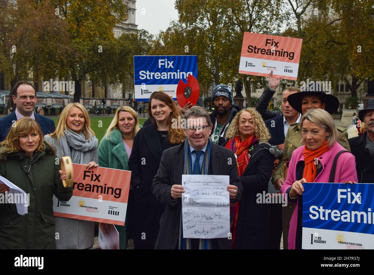 Londra, Regno Unito. 24 novembre 2021. Il deputato del lavoro Kevin Brennan (c) detiene una copia del suo Copyright Bill firmato da vari sostenitori durante la manifestazione.musicisti, membri dell'Unione dei musicisti e altri riuniti in Piazza del Parlamento a sostegno del diritto d'autore (diritti e remunerazione dei musicisti, ecc.) Bill, che garantirebbe che i musicisti ricevano una remunerazione equa. Credit: SOPA Images Limited/Alamy Live News Foto Stock