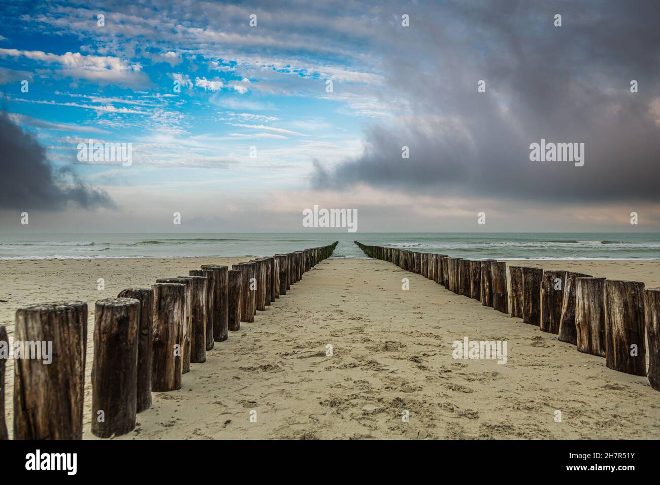Spiaggia di sabbia a Burgh-Haamstede nella provincia olandese di Zeeland con una doppia fila di pali di spiaggia in mare inteso come protezione costiera funzionale Foto Stock