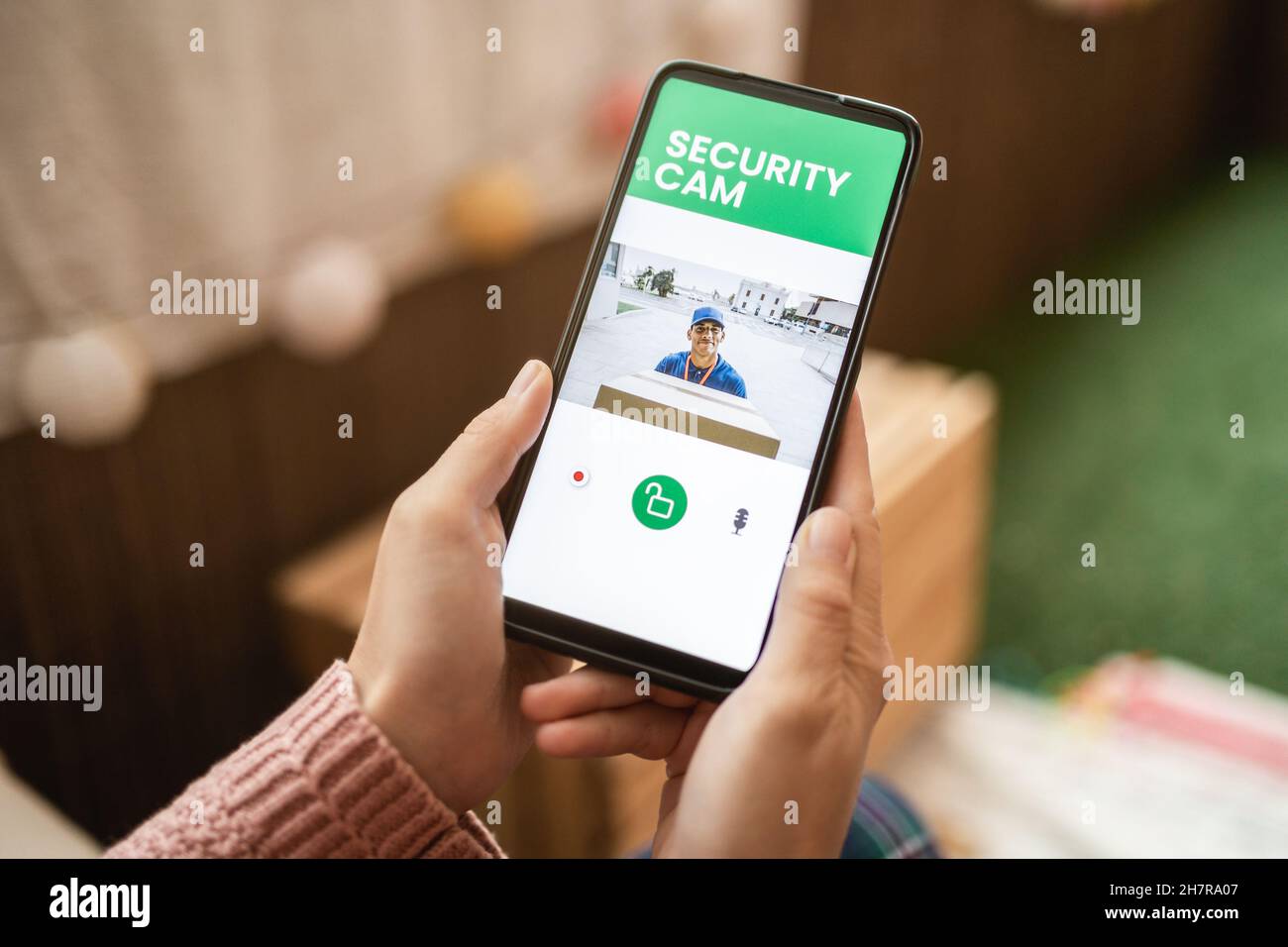 Addetto alla consegna che squilla la campana della porta sul sistema cctv Secure camera sull'app del telefono cellulare Foto Stock