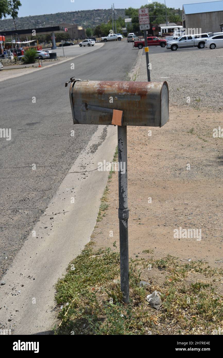 Vecchia cassetta postale in metallo arrugginito sul montante del tubo. Foto Stock