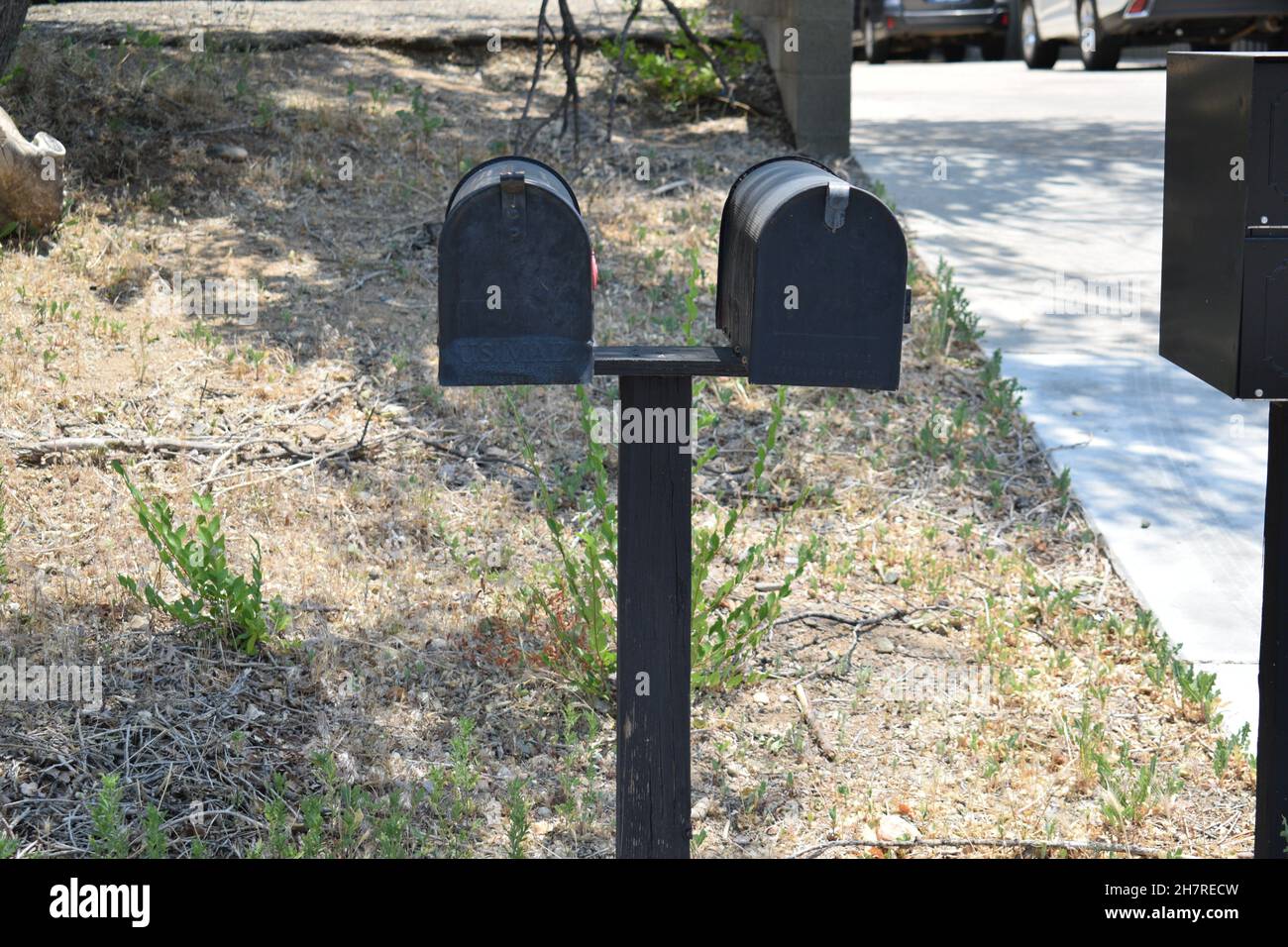 Due mailbox nere su un singolo post. Foto Stock