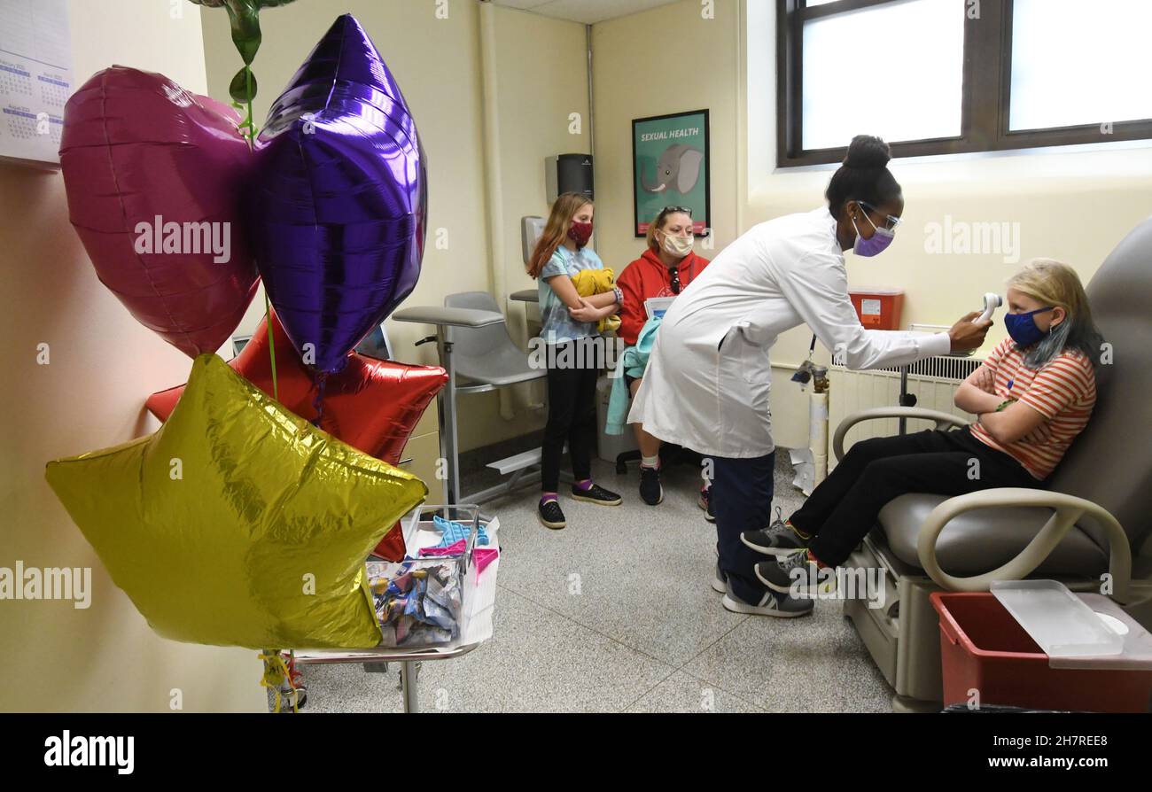 Racine, Wisconsin, Stati Uniti. 24 novembre 2021. EMILY CHAFFEE, 8, ha la sua temperatura presa da JALEESA JENKIN R.N. come la città di Racine, Wisconsin tiene un bambino COVID-19 Pfizer clinica di vaccino al dipartimento di salute della città Mercoledì. Babbo Natale era a disposizione per dare ai bambini canne di caramelle, pastelli e libri da colorare dopo che erano stati inoculati. Gli adulti potrebbero anche ottenere inoculato. I residenti della città di adulti e bambini che ottengono i loro primi colpi hanno ricevuto buoni regalo $50. (Credit Image: © Mark Hertzberg/ZUMA Press Wire) Foto Stock
