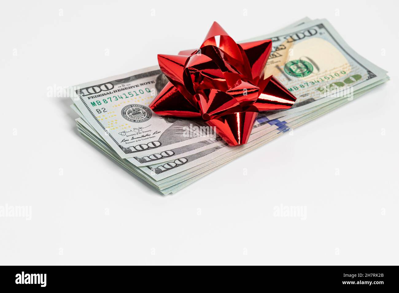 Regalo in contanti di 100 dollari con arco rosso. Tassa regalo, donazione benefica e regalo vacanza concetto. Foto Stock
