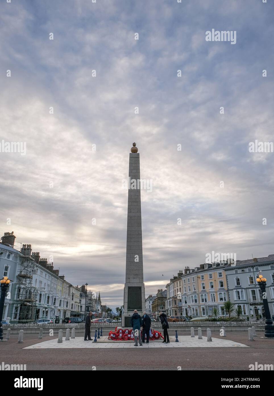 Una vista del memoriale di guerra a Llandudno, visto al tramonto da passanti. Un grande cielo enfatizza il senso di perdita. Foto Stock
