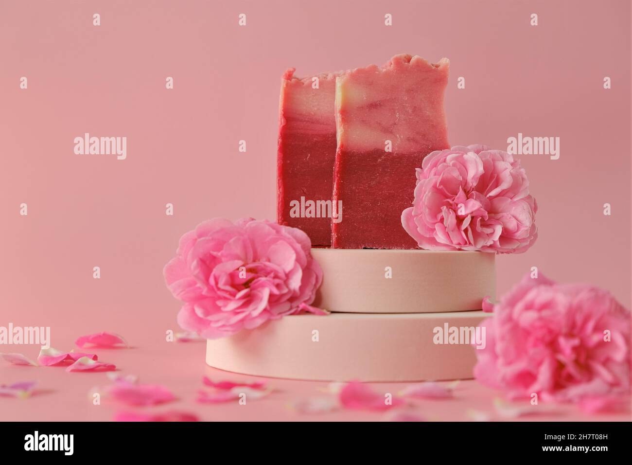 Sapone di rose. Bellezza e aromaterapia. Sapone di fiore. Saponette rosa e rose rosa su sfondo rosa. Foto Stock