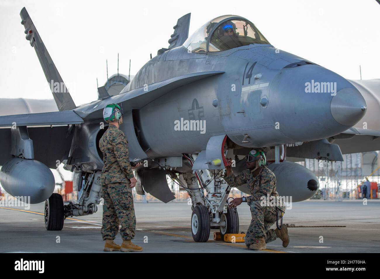 Corpo Marino degli Stati Uniti Gunnery Sgt. Eric Smith (a sinistra) e Sgt. Ndaih Atanga (a destra), tecnici dell'avionica con Marine Fighter Attack Squadron 112, effettuano controlli pre-volo su un aereo F/A-18C Hornet presso Marine Corps Air Station (MCAS) Iwakuni, Giappone, 18 novembre 2021. VMFA-112 ha partecipato ad una prova congiunta dello sciopero marittimo con la Marina degli Stati Uniti al largo della costa di Okinawa, 19 novembre 2021. I Marines statunitensi con VMFA-112 addestrano e provano regolarmente i set di missioni marittime congiunte al fine di mantenere la disponibilità a svolgere un'ampia gamma di compiti operativi in una regione caratterizzata da vasti oceani, mari e wate Foto Stock