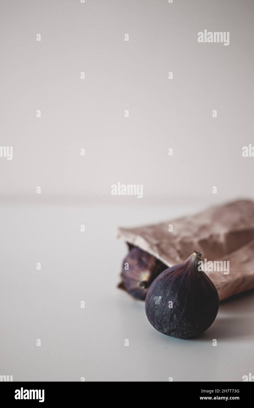 Raccolta di frutta fresca di fichi interi maturi sulla carta artigianale marrone. Cibo biologico. Minimalismo, spazio di copia Foto Stock