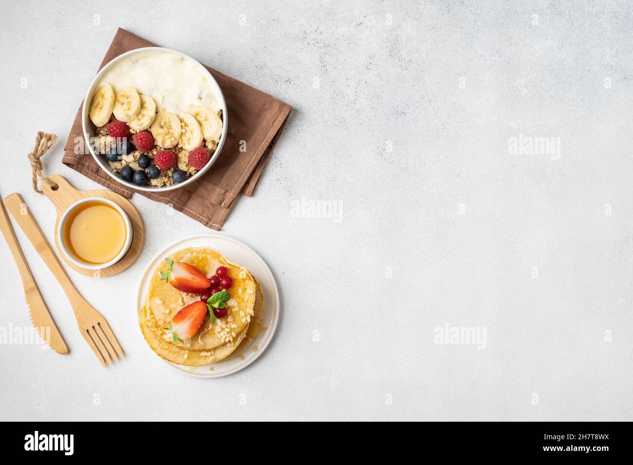 Colazione servita al mattino: Pancake, porridge, formaggio caserma, muesli, succo d'arancia, tè, caffè, frutta e frutti di bosco. Foto Stock