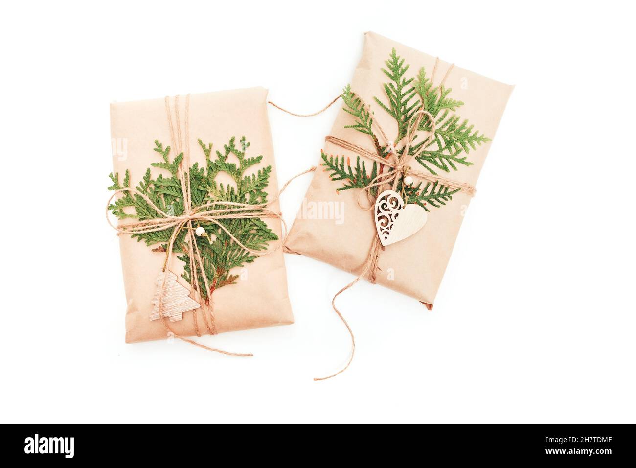 Confezione regalo avvolta in carta artigianale decorata con cono di pino su sfondo bianco Foto Stock