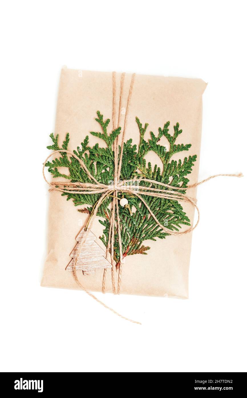 Confezione regalo avvolta in carta artigianale decorata con cono di pino su sfondo bianco Foto Stock