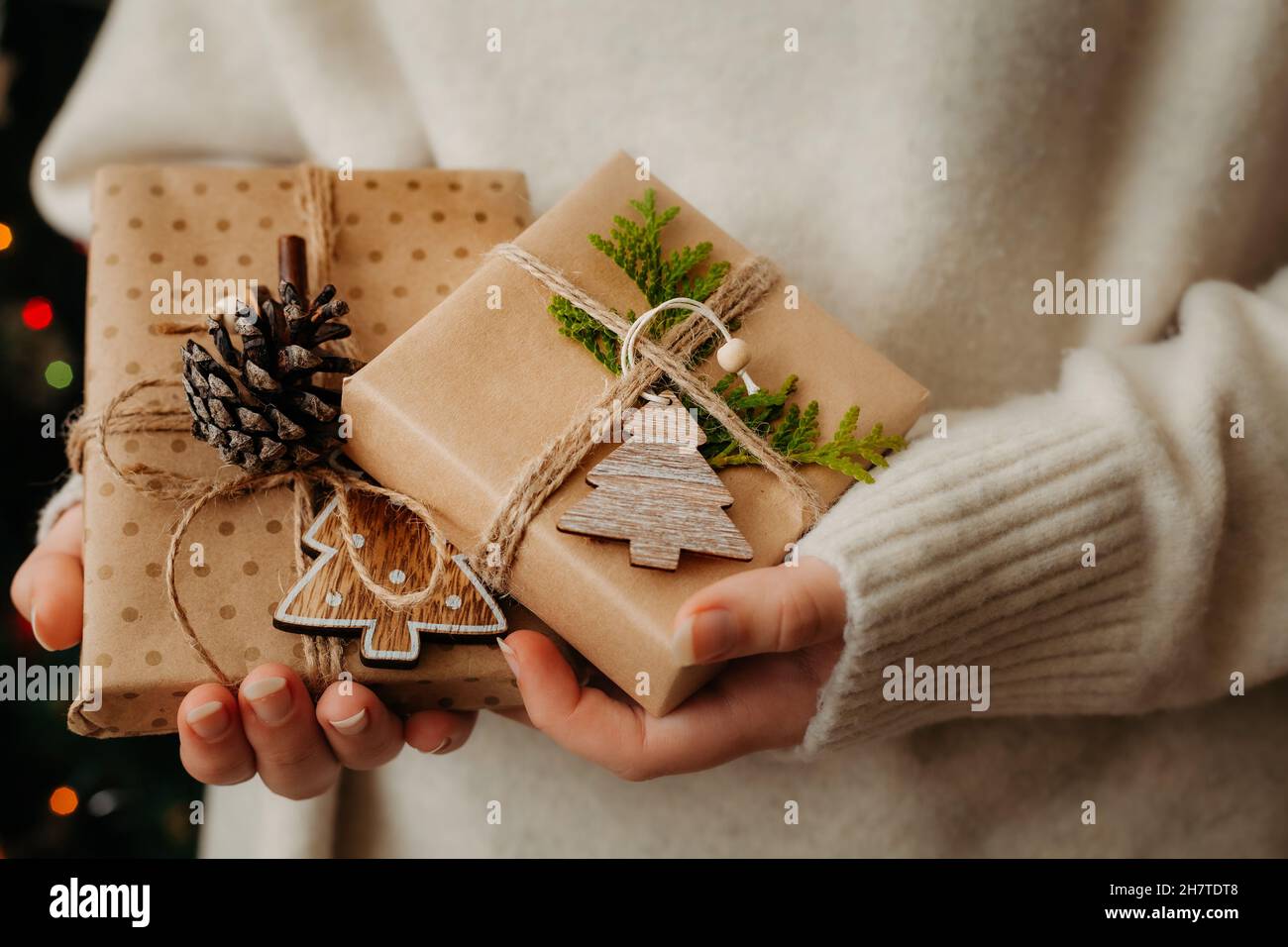 Due piccole confezioni regalo in mani femminili. Primo piano. Nizza presenta avvolto in carta artigianale, zero concetto di spreco Foto Stock