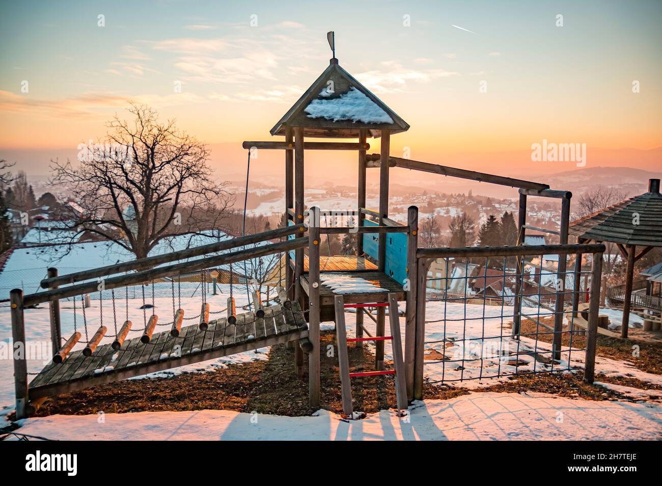 Il parco giochi per bambini è coperto di neve ed è vuoto in una fredda giornata invernale in Austria Foto Stock