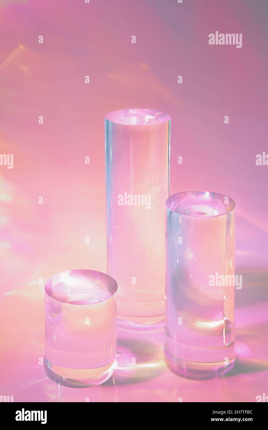 tre podi in vetro chiaro su sfondo rosa pastello Foto Stock