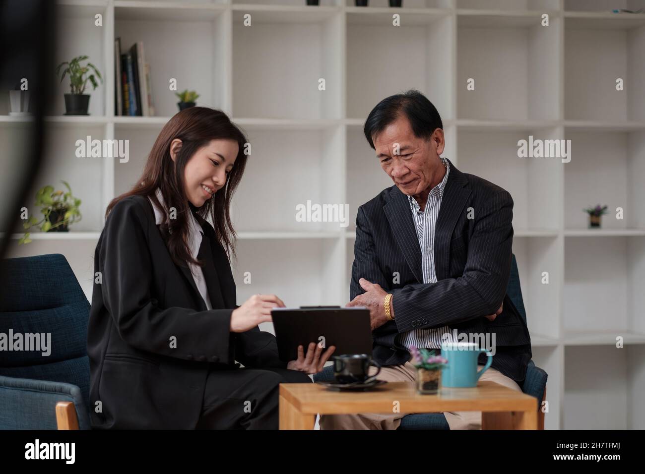 Amichevole avvocato o consulente finanziario in tuta consulenza anziano uomo, sorridente intermediario di investimento o lavoratore bancario che fanno prestito offerta, dando consulenza legale Foto Stock