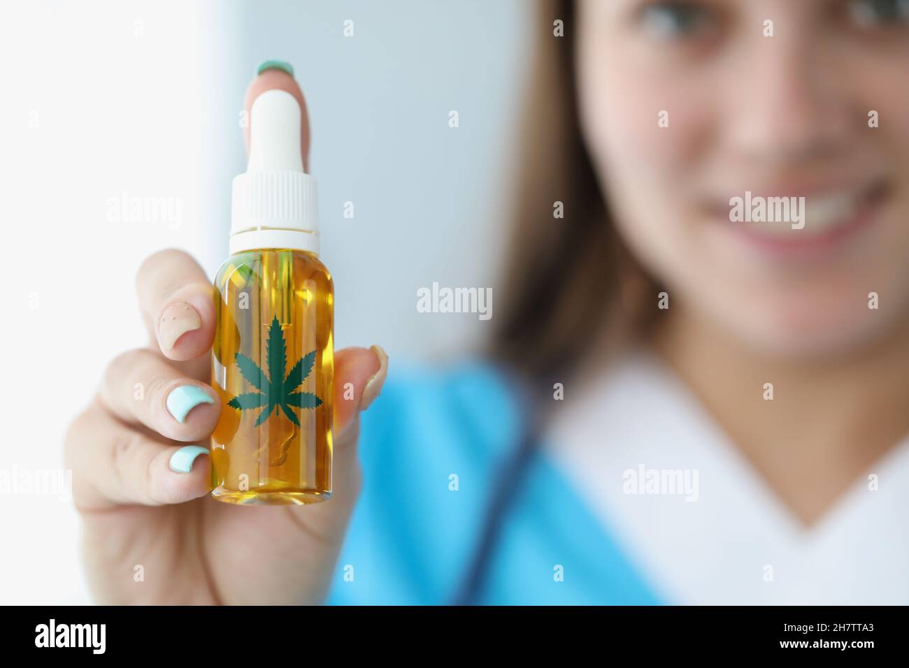 L'operatore medico presenta l'olio di cannabis in bottiglia di plastica per un trattamento alternativo Foto Stock