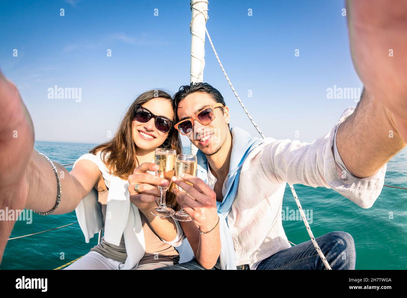Giovane coppia in amore prendere selfie in barca a vela brulicando con vino champagne - Happy Jubilee party crociera viaggio in barca a vela di lusso con ragazzo Foto Stock