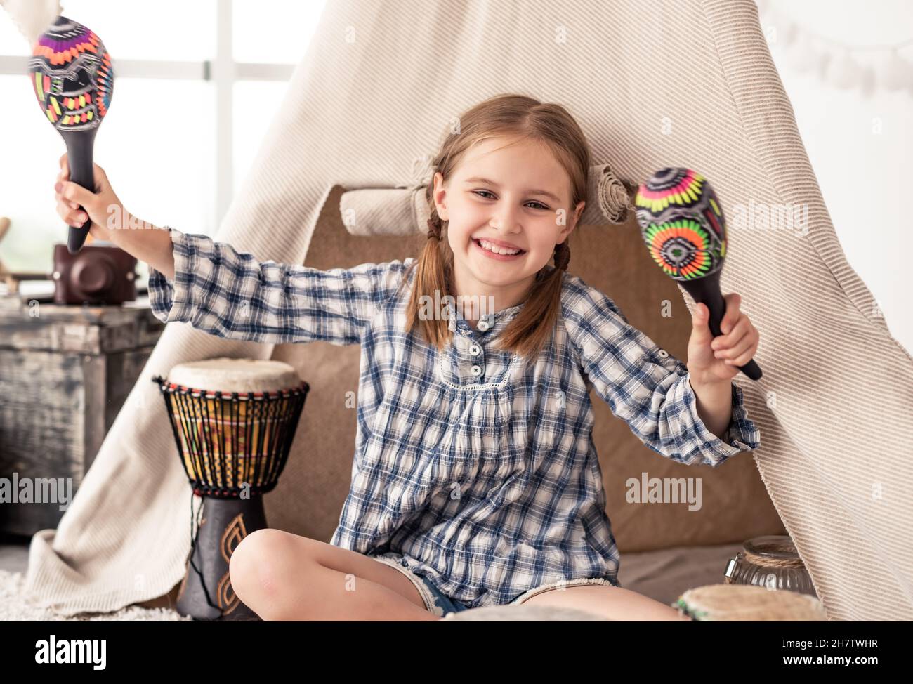 Bambina con maracas e tamburi djembe Foto Stock