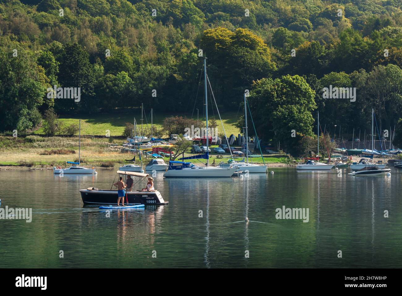 Vacanze Regno Unito, vedere in estate di persone che chiacchierano mentre a galla sul lago Windermere, il lago più lungo in Inghilterra a 10,5 miglia, Lake District, Cumbria, Regno Unito Foto Stock