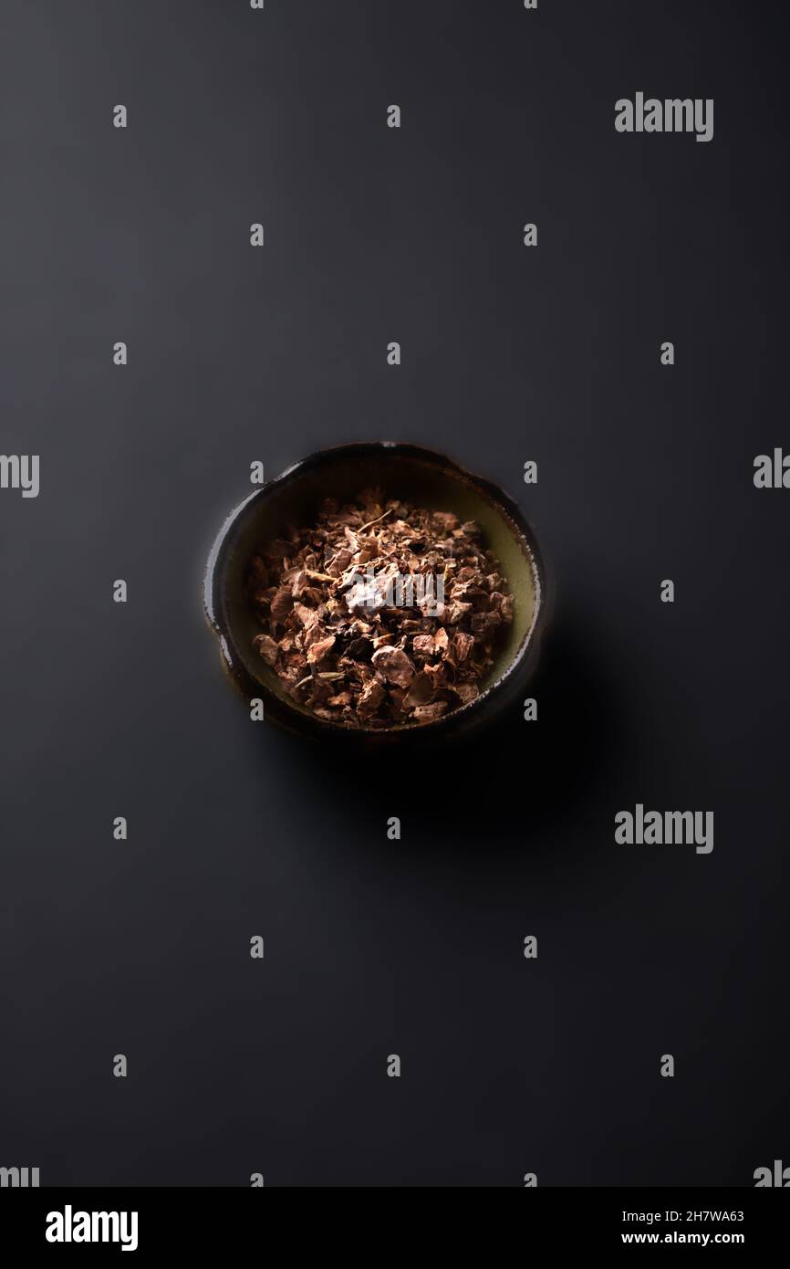 Radice secca di rosea di Rhodiola. Radice d'oro, radice di rosa. Pianta medica sana su sfondo di carta scuro. Primo piano. Spazio di copia. Foto Stock