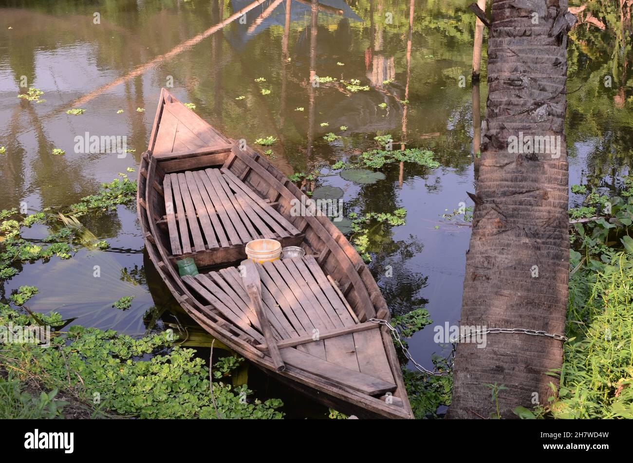 Le barche sono legate alle palme nel piccolo canale del villaggio profondo Foto Stock