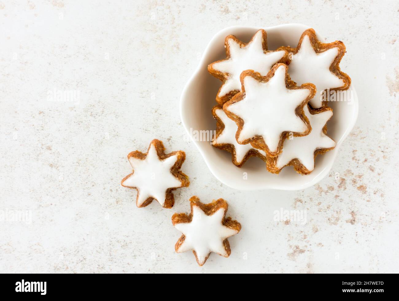 Vista dall'alto di biscotti alla cannella star, Zimtsterne tradizionale tedesca in una ciotola bianca. Spazio di copia. Foto Stock