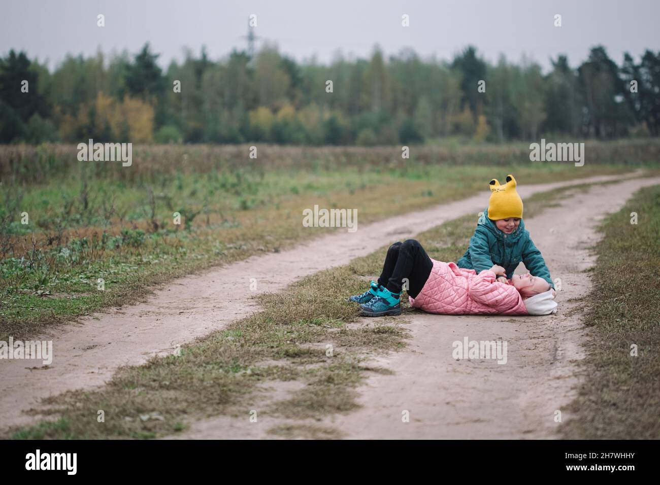 Piccoli bambini caucasici che giocano nel campo autunno tempo. Foto Stock