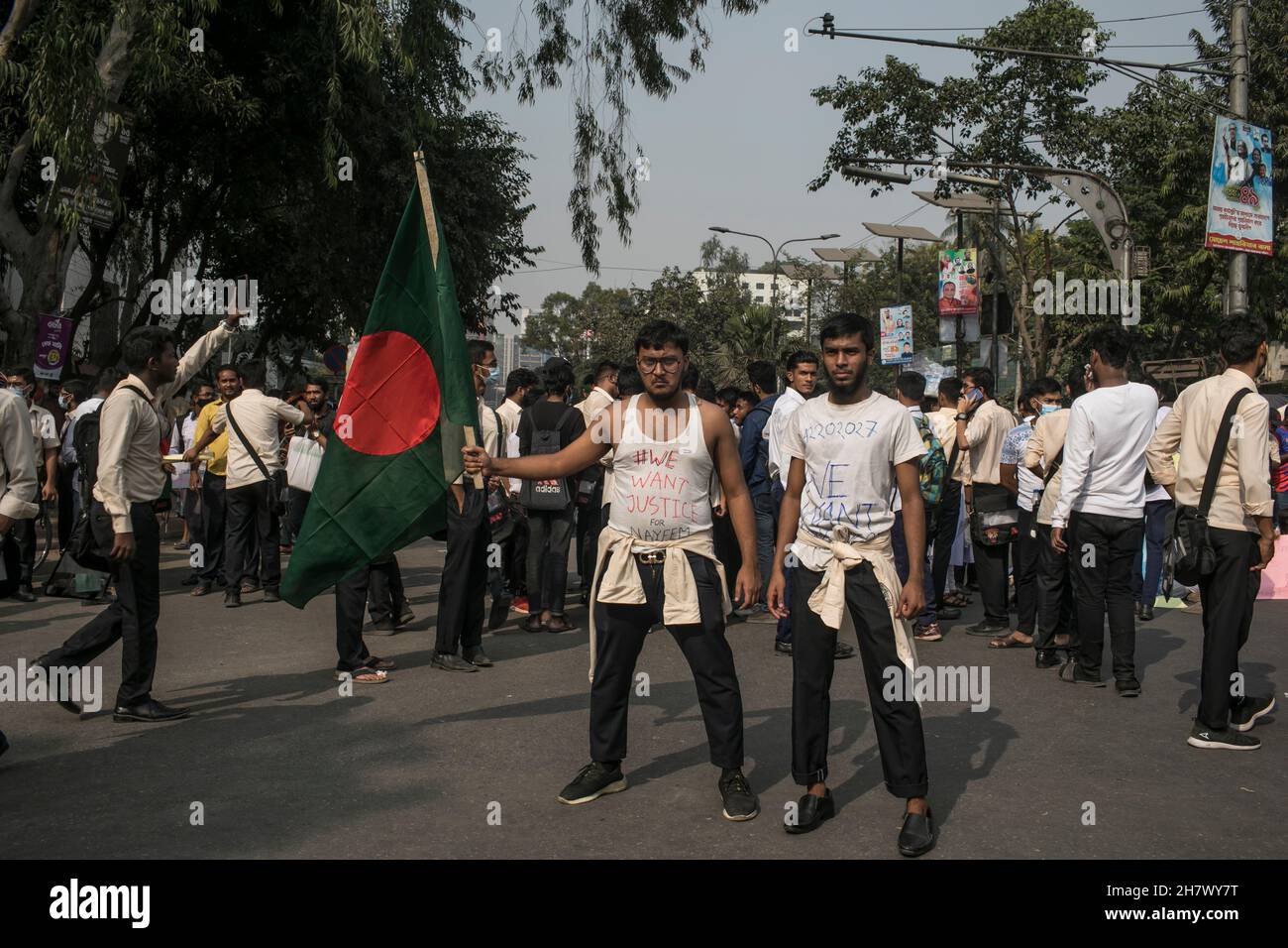 Due studenti hanno visto al terreno di protesta indossando sotto le camicie con le parole "vogliamo la giustizia" mentre tendevano una bandiera durante la protesta di sicurezza stradale a Dhaka.studenti di diverse istituzioni educative continuano le loro dimostrazioni per il secondo giorno a Dhaka chiedendo la sicurezza sulle strade dopo la morte di A. Studente del Notre Dame College in un incidente. Nayeem Hasan, studente del secondo anno del college, è stato ucciso in un incidente stradale mercoledì. Foto Stock