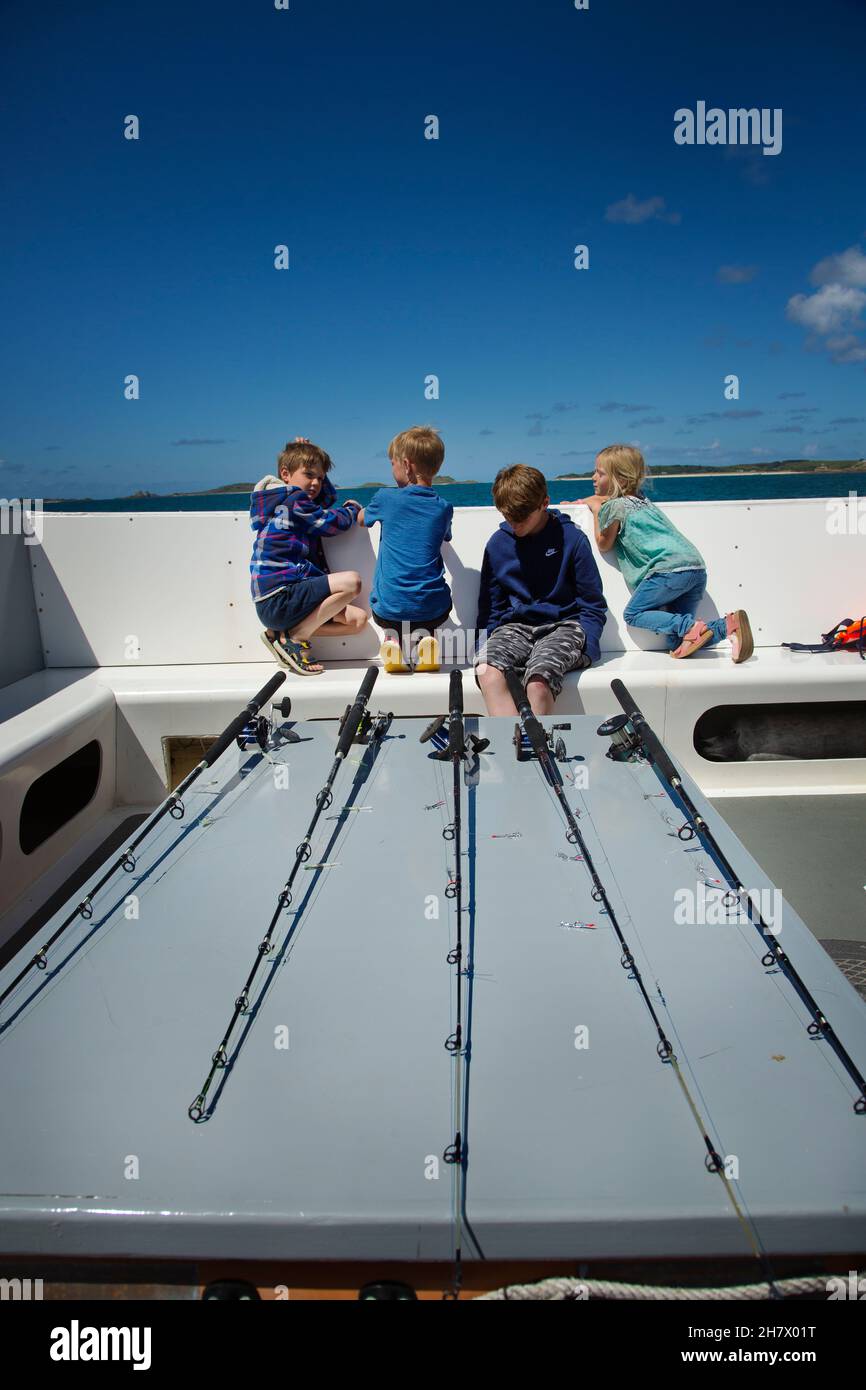 I bambini che fanno un viaggio di pesca in mare Foto Stock