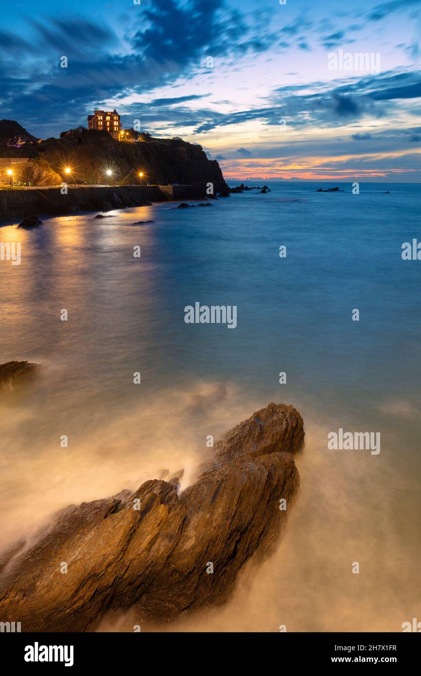 Granville Point condominio illuminato dietro Wildersmouth Beach Ilfracombe Devon Inghilterra GB Europa Foto Stock