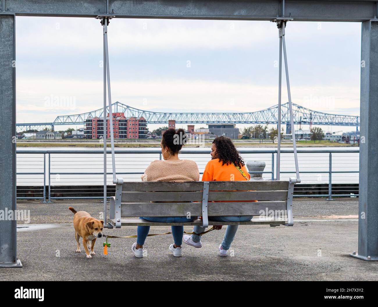 NEW ORLEANS, LOUISIANA - 5 DICEMBRE 2020: Coppia in altalena con il cane lungo il fiume Mississippi a Crescent Park Foto Stock