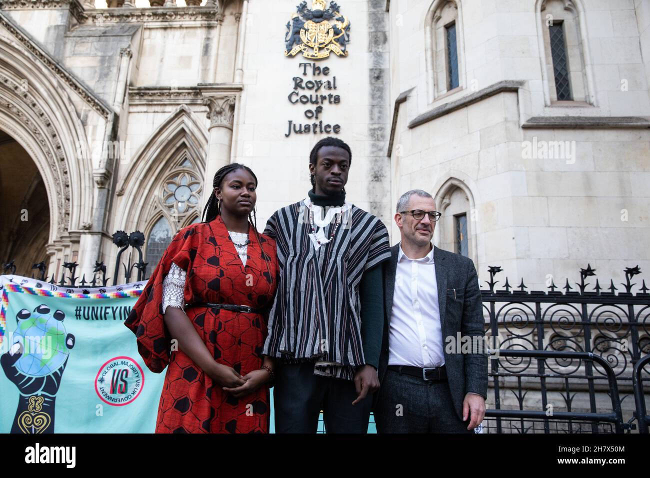 Londra, Regno Unito. 25 novembre 2021. Adetola Onamade, Jerry Amokwandoh e Tim Crosland (l-r) si pongono fuori dalle corti reali di giustizia davanti ad un appello per conto del piano B.Earth, Crosland e di tre giovani cittadini britannici (Marina Tricks, Onamade e Amokwandoh) Con la famiglia nell’Africa occidentale e nelle Americhe che sostiene che i loro diritti umani sono violati dal mancato intervento del governo britannico sulla crisi climatica. I tre studenti hanno chiesto una revisione giudiziaria delle azioni governative volte a ridurre le emissioni nazionali di carbonio e hanno sostenuto che l’azione del governo britannico, o l’inazione, non tiene conto Foto Stock