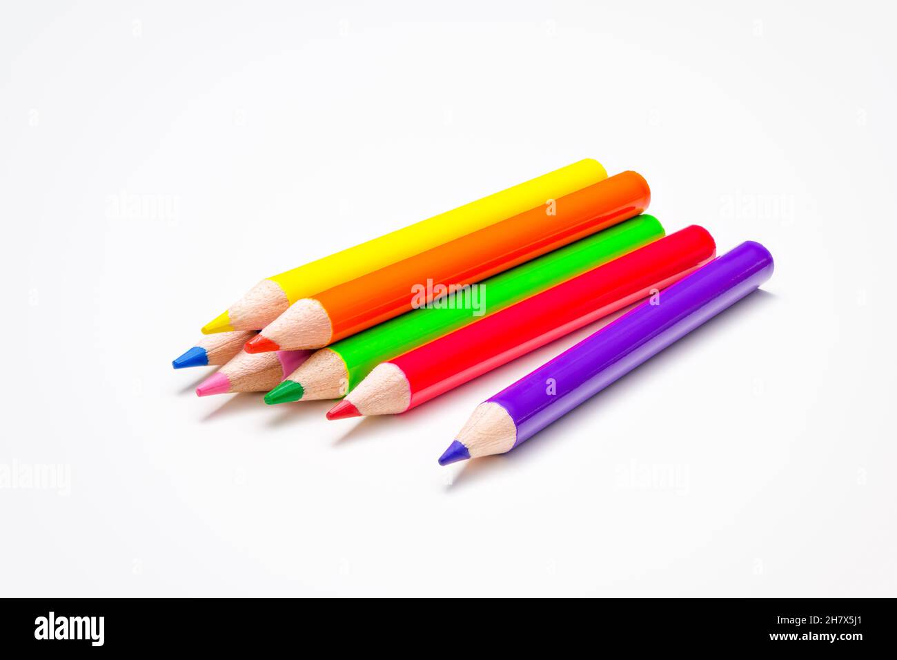 Infanzia, ritorno a scuola, istruzione, creatività. Sette penne in colori arcobaleno luminosi su sfondo bianco della scrivania. Foto Stock