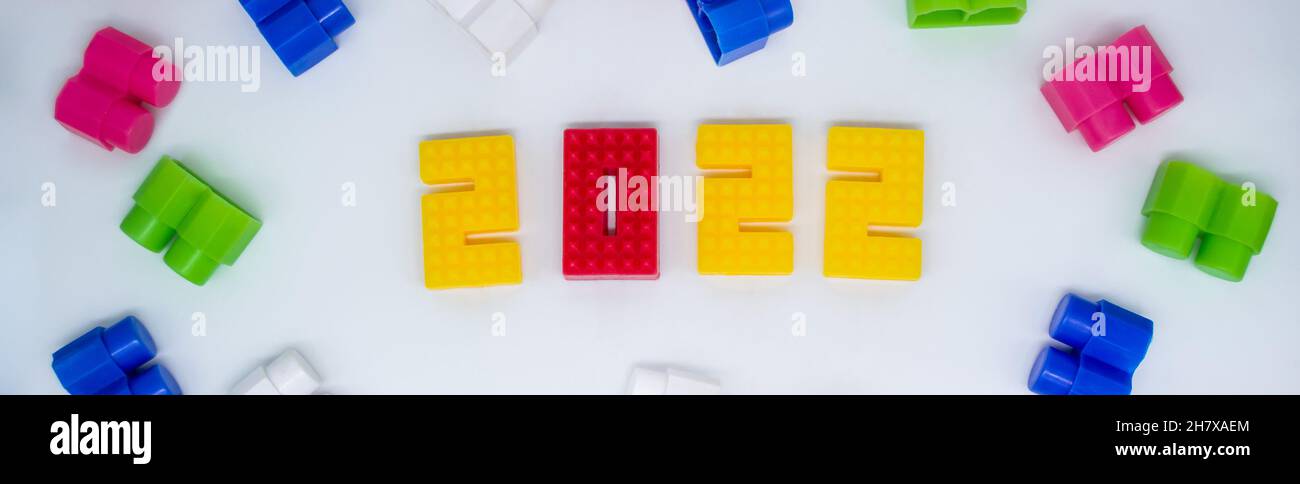 Banner colorati blocchi da costruzione, giocattoli plastica figura su sfondo bianco. Foto Stock