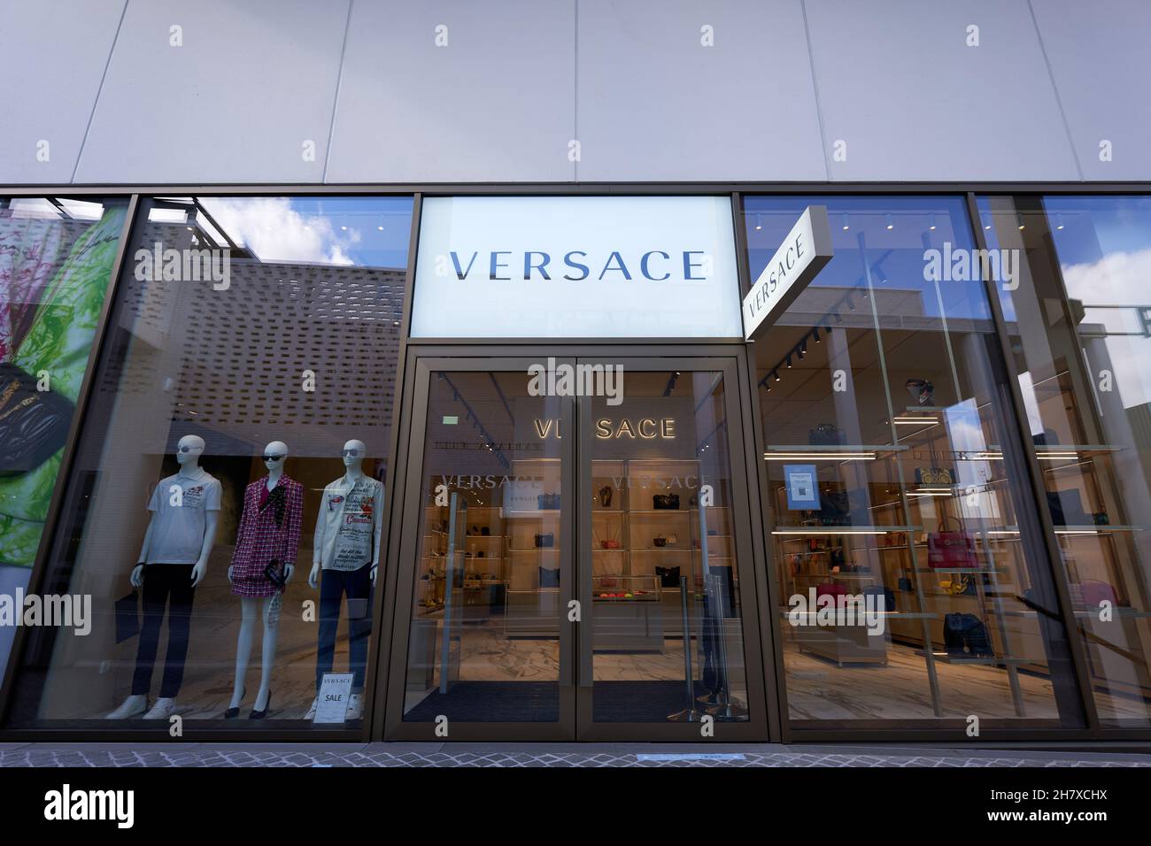 Metzingen, Germania - 20 marzo 2021: Negozio outlet Versace. Vetrina con manichino. Ingresso principale in vetro. Vista frontale. Foto Stock