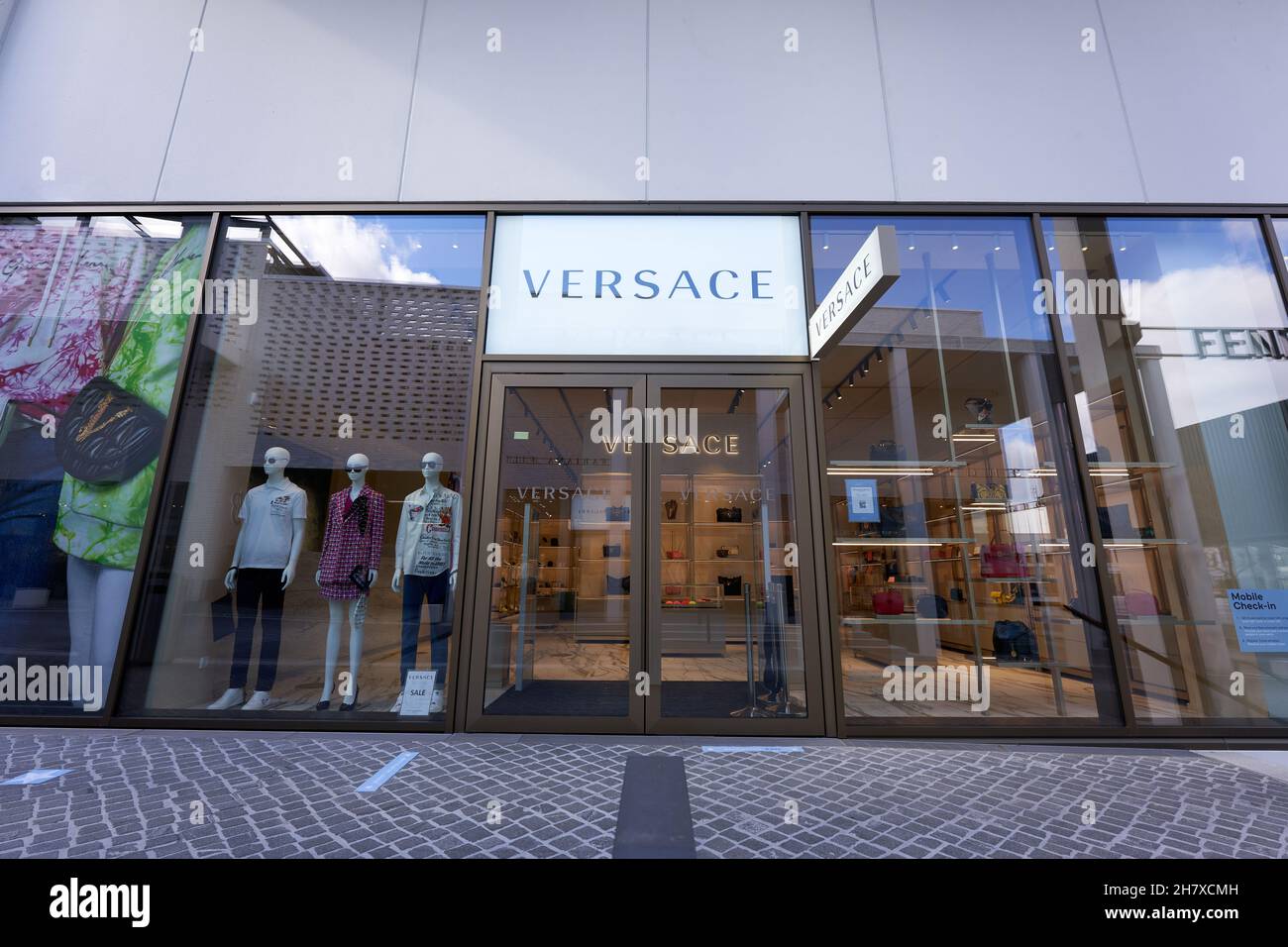 Metzingen, Germania - 20 marzo 2021: Negozio outlet Versace. Vetrina con manichino. Ingresso principale in vetro. Vista frontale. Grandangolo. Foto Stock