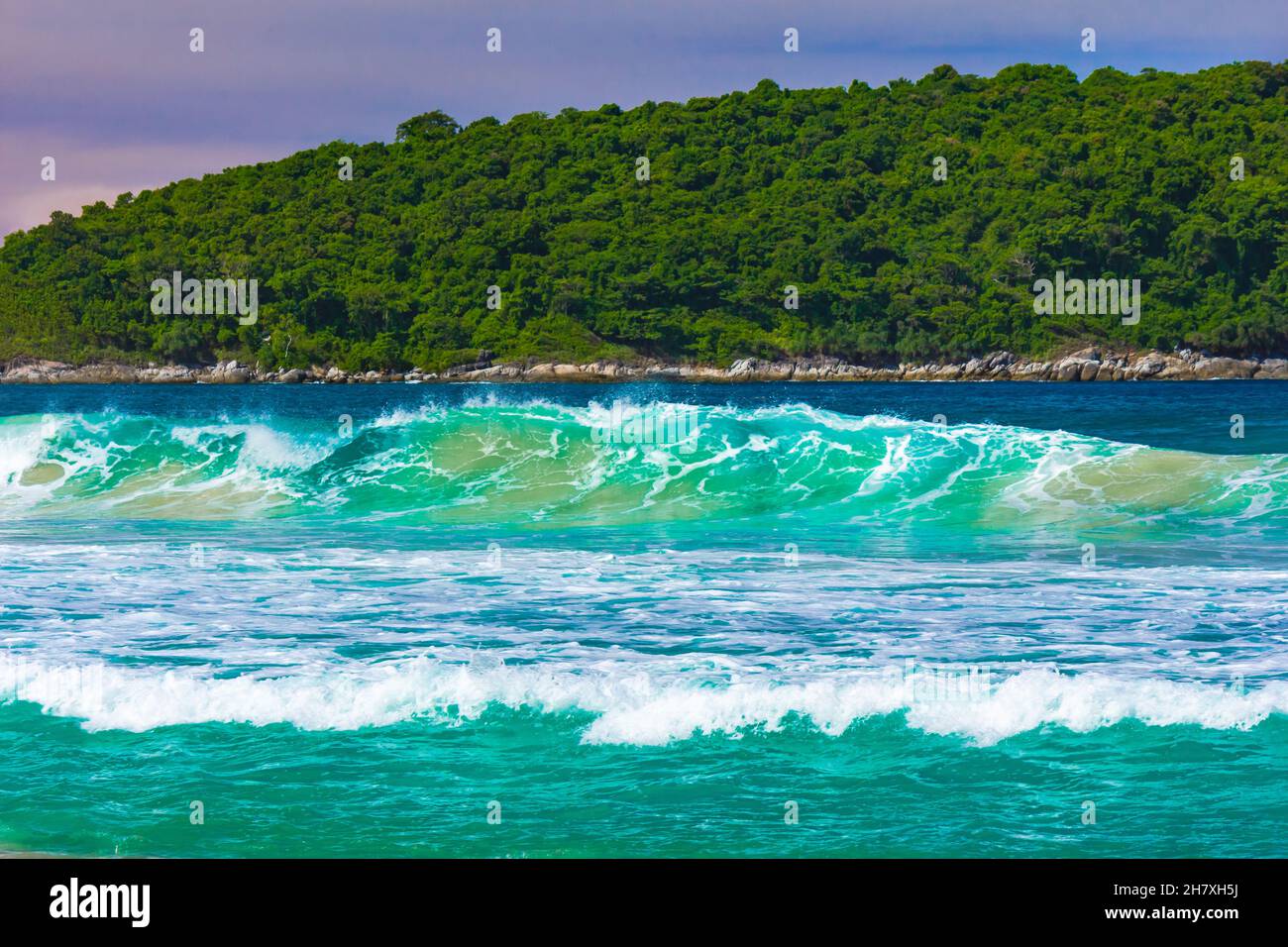 Ondate su una spiaggia tropicale sullo sfondo dell'isola Foto Stock