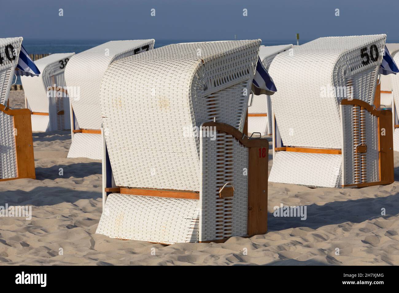 Alcuni moderni lettini da spiaggia coperti sono nello stile di un vecchio modello, che in precedenza era fatto di vimini e ora potete vederli sulla spiaggia a Kol Foto Stock