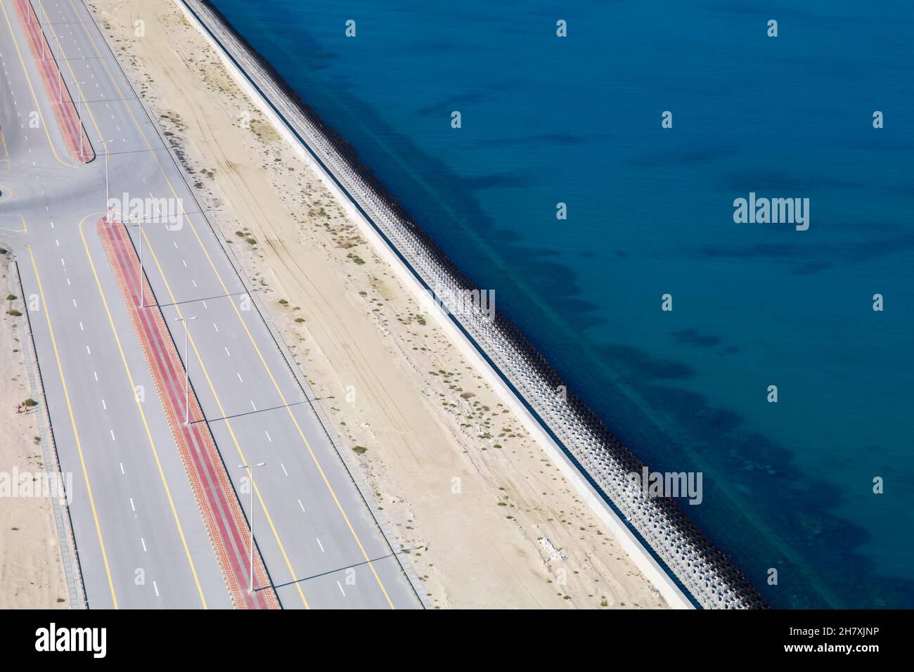 Breakwater con una strada asfaltata vuota su di esso, vista aerea Foto Stock