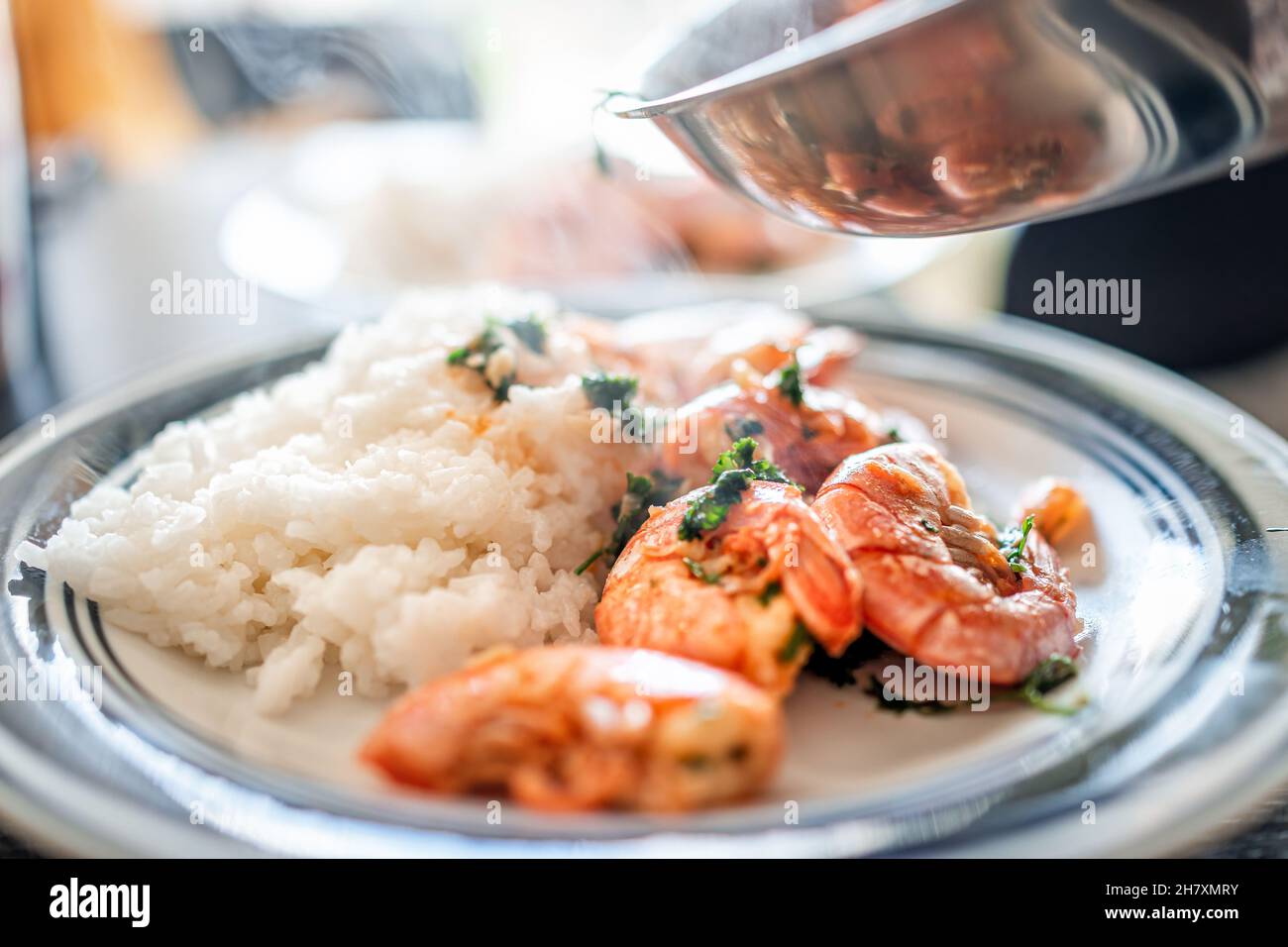 Macro closeup vista laterale di sauteed cotto intero grande re Jumbo gamberi argentini frutti di mare con riso asiatico bianco in olio d'oliva aglio affettato con crema Foto Stock