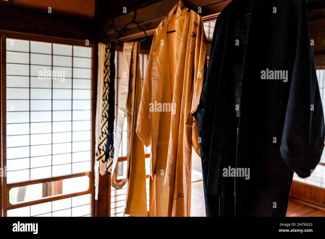 Tradizionale machiya casa giapponese o hotel di ryokan con porta di carta scorrevole shoji e luce con architettura e kimono appeso con cintura di Sash obi Foto Stock