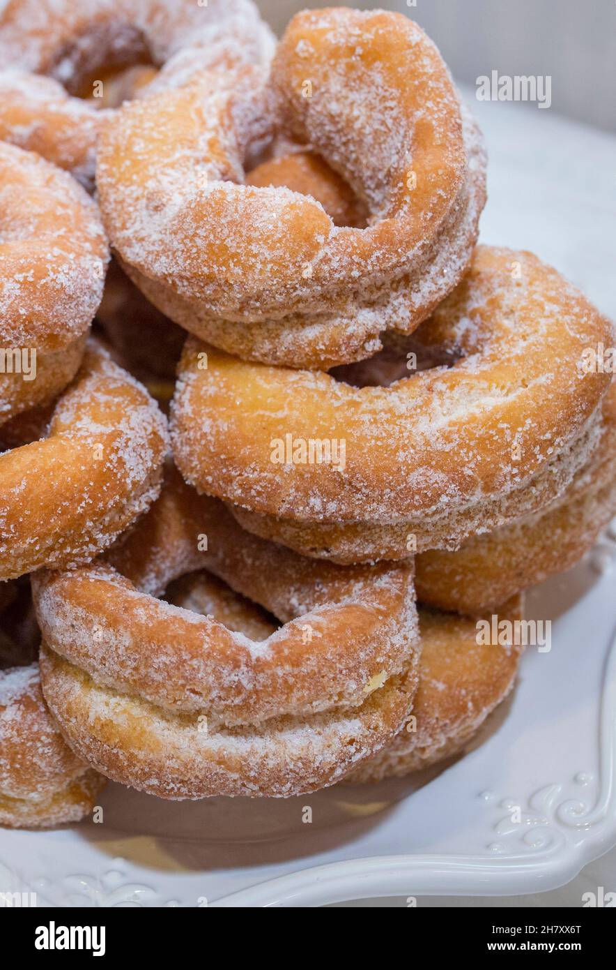 Ciambelle fritte o rosche fritas spagnole. Spolverato con zucchero e placcato in porcellana Foto Stock